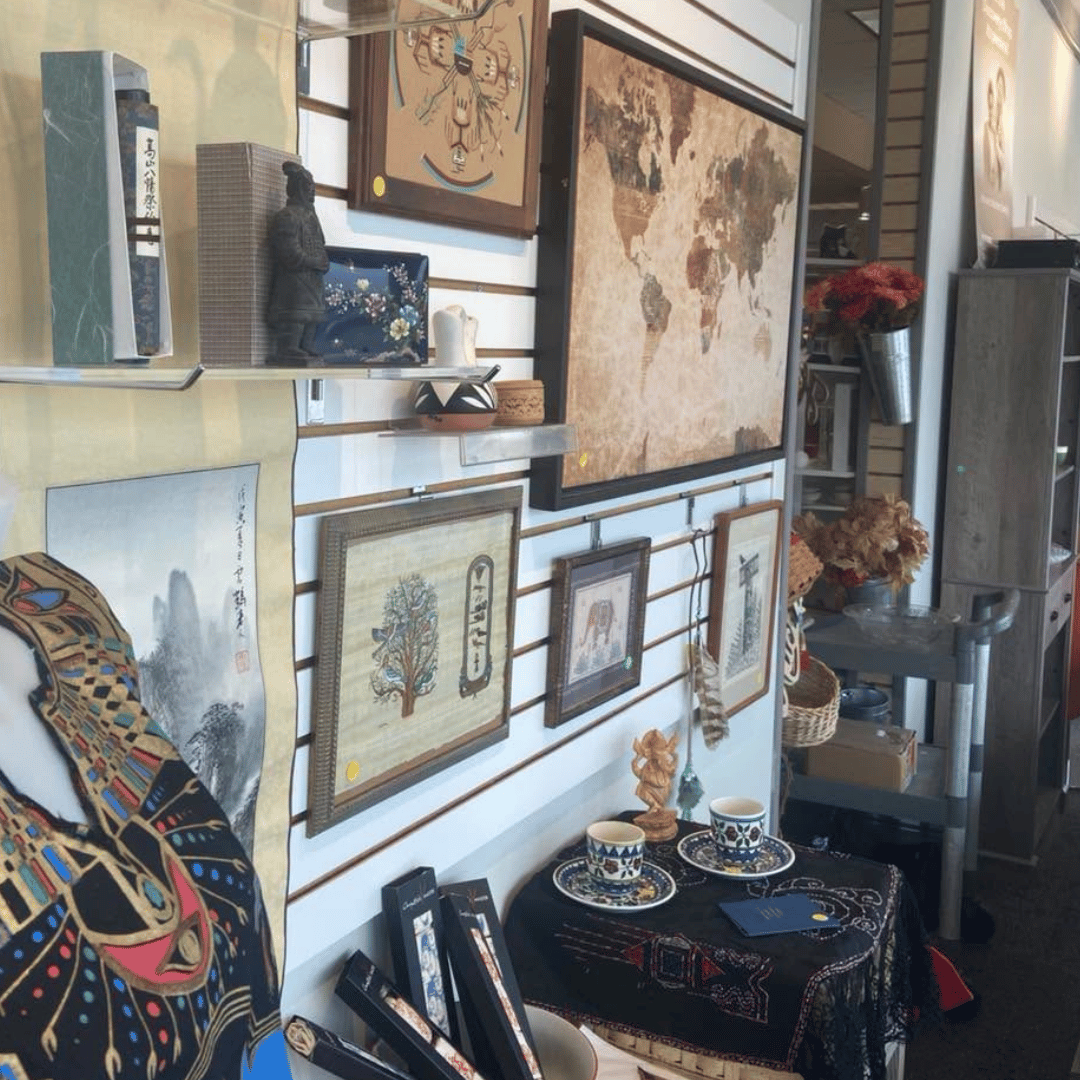 Wall of framed art and decor displays beside a small table with dishes in a cozy home interior
