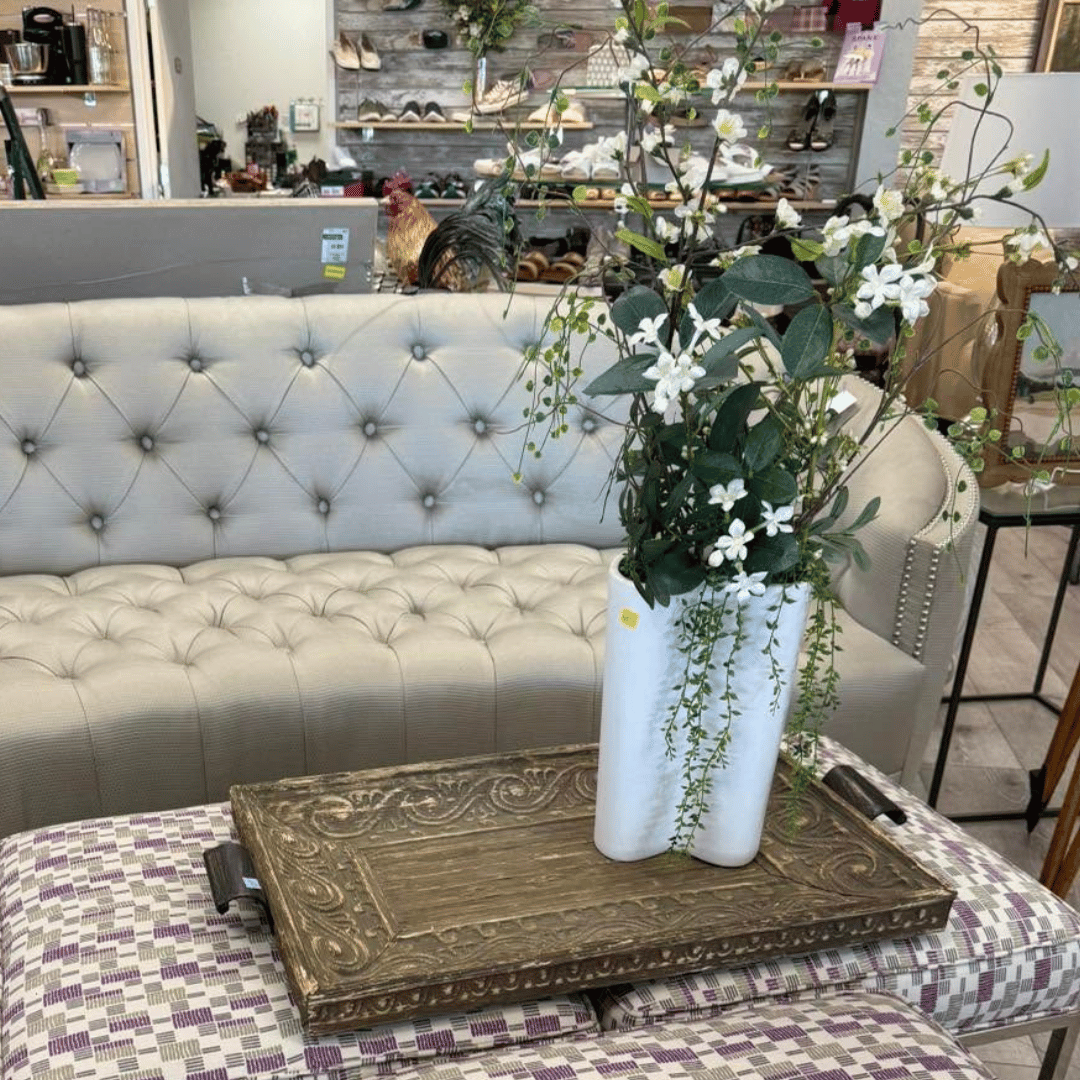 Rustic flower shop display with colorful potted blooms, birdhouses, candles, and decorative shelves