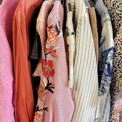 Colorful patterned dresses hanging closely together on a clothing rack