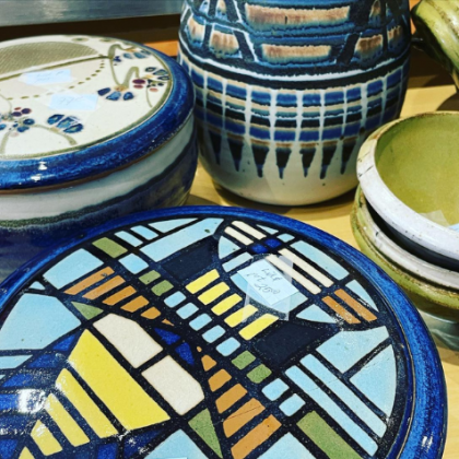 Colorful hand-painted ceramic bowls with blue, yellow, and white geometric patterns displayed together