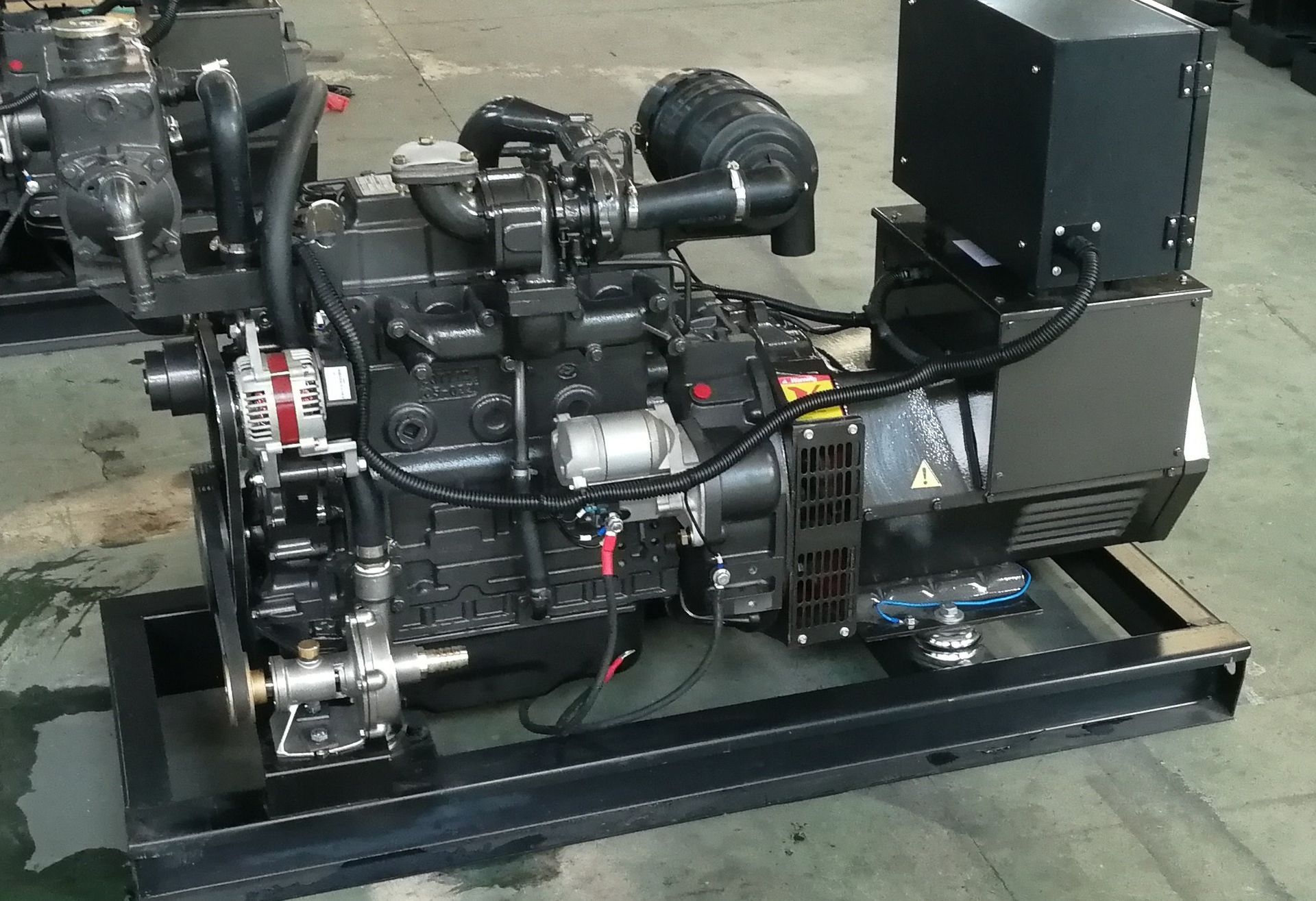 A diesel generator is sitting on top of a concrete floor.