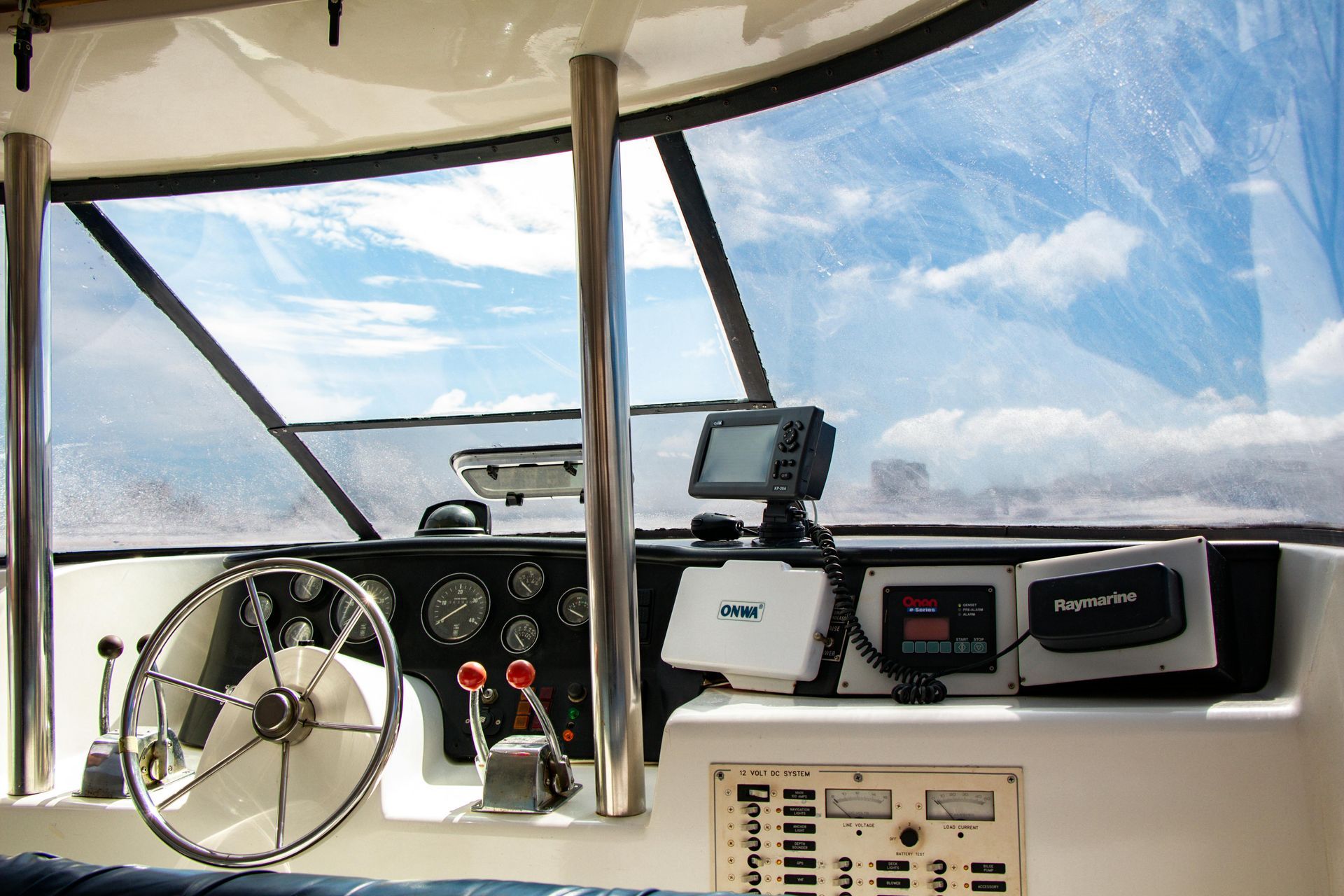 The inside of a boat with a steering wheel