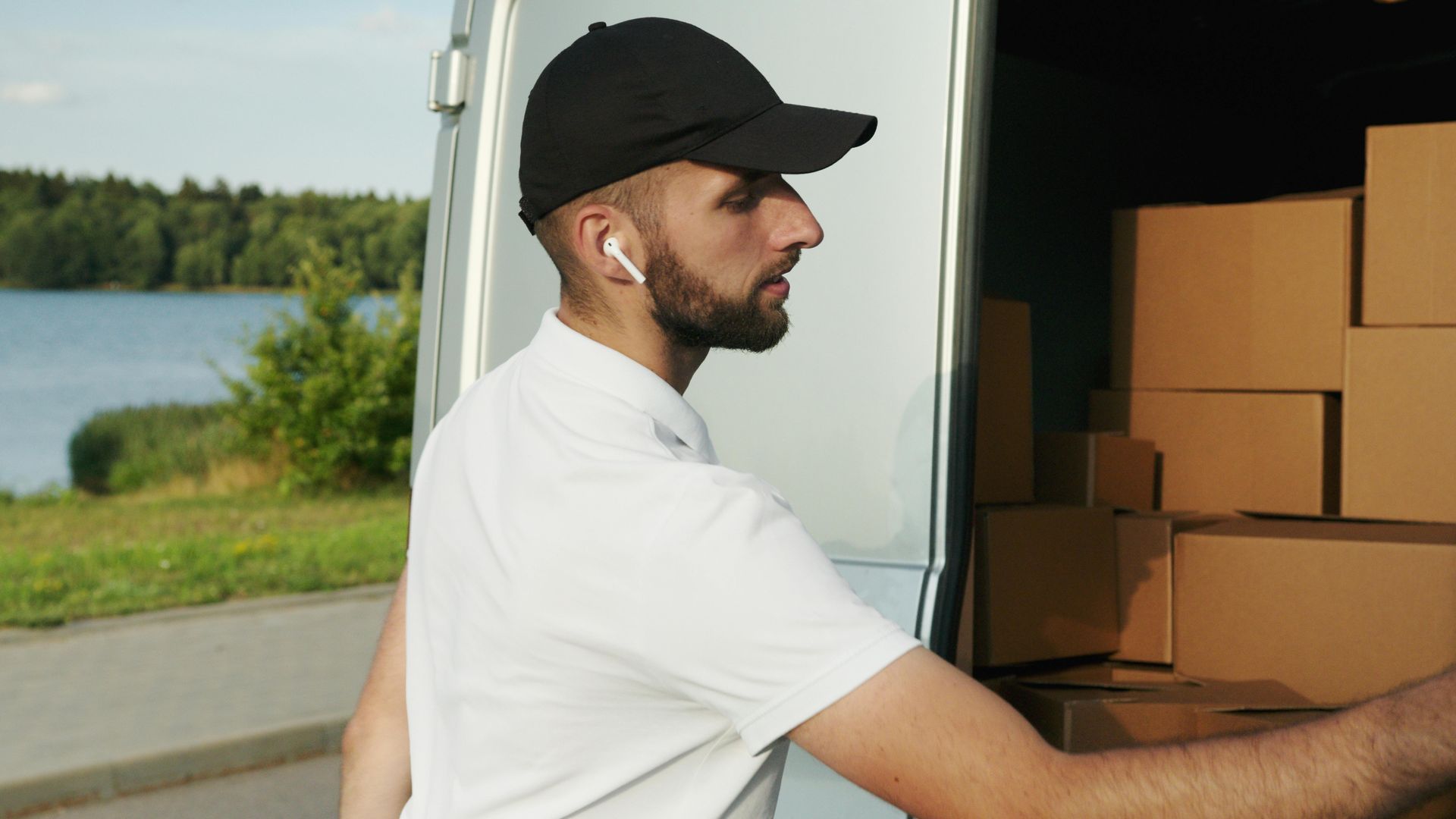 A delivery man is loading boxes into a van.
