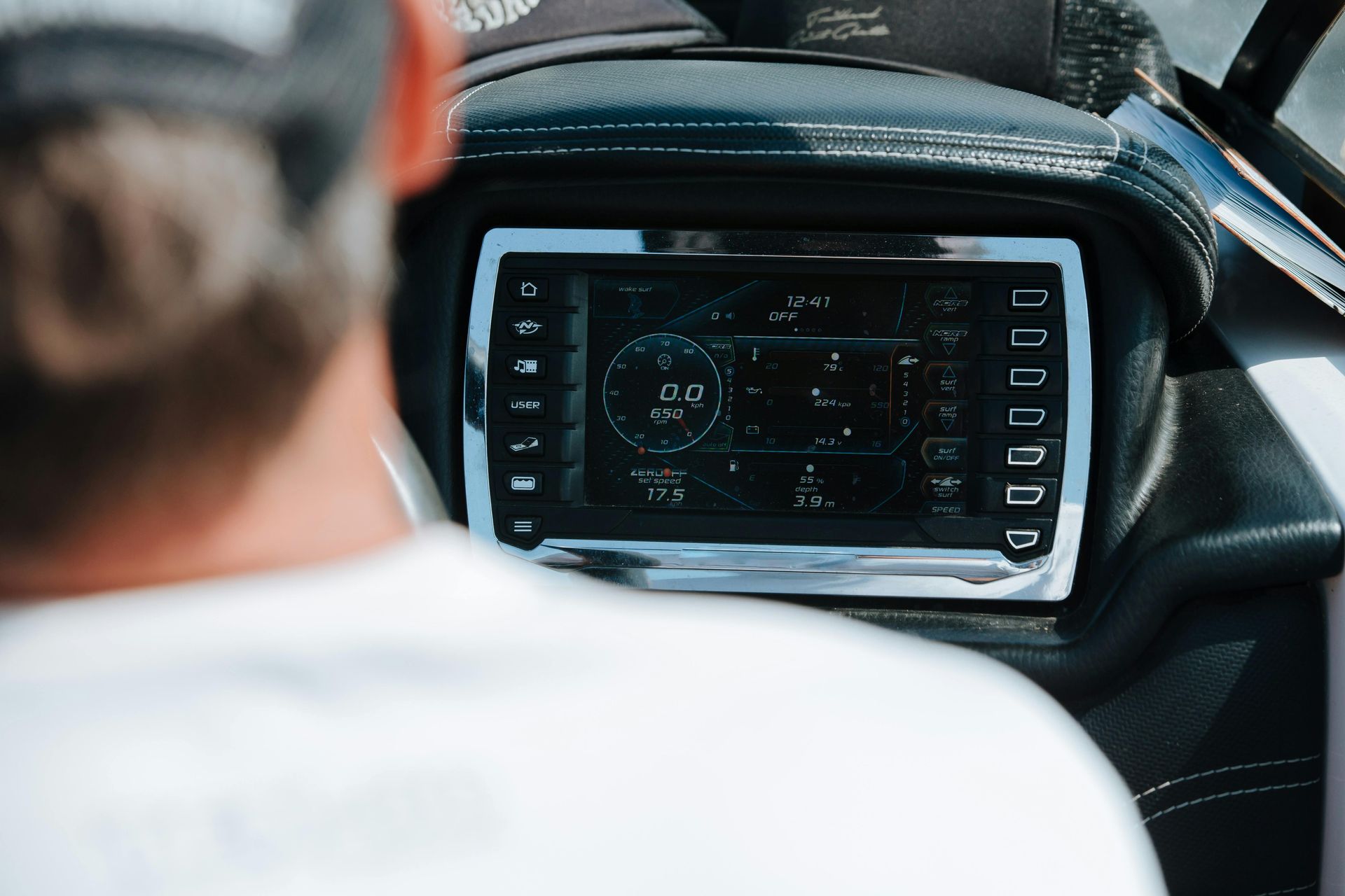 A man is looking at the dashboard of a boat