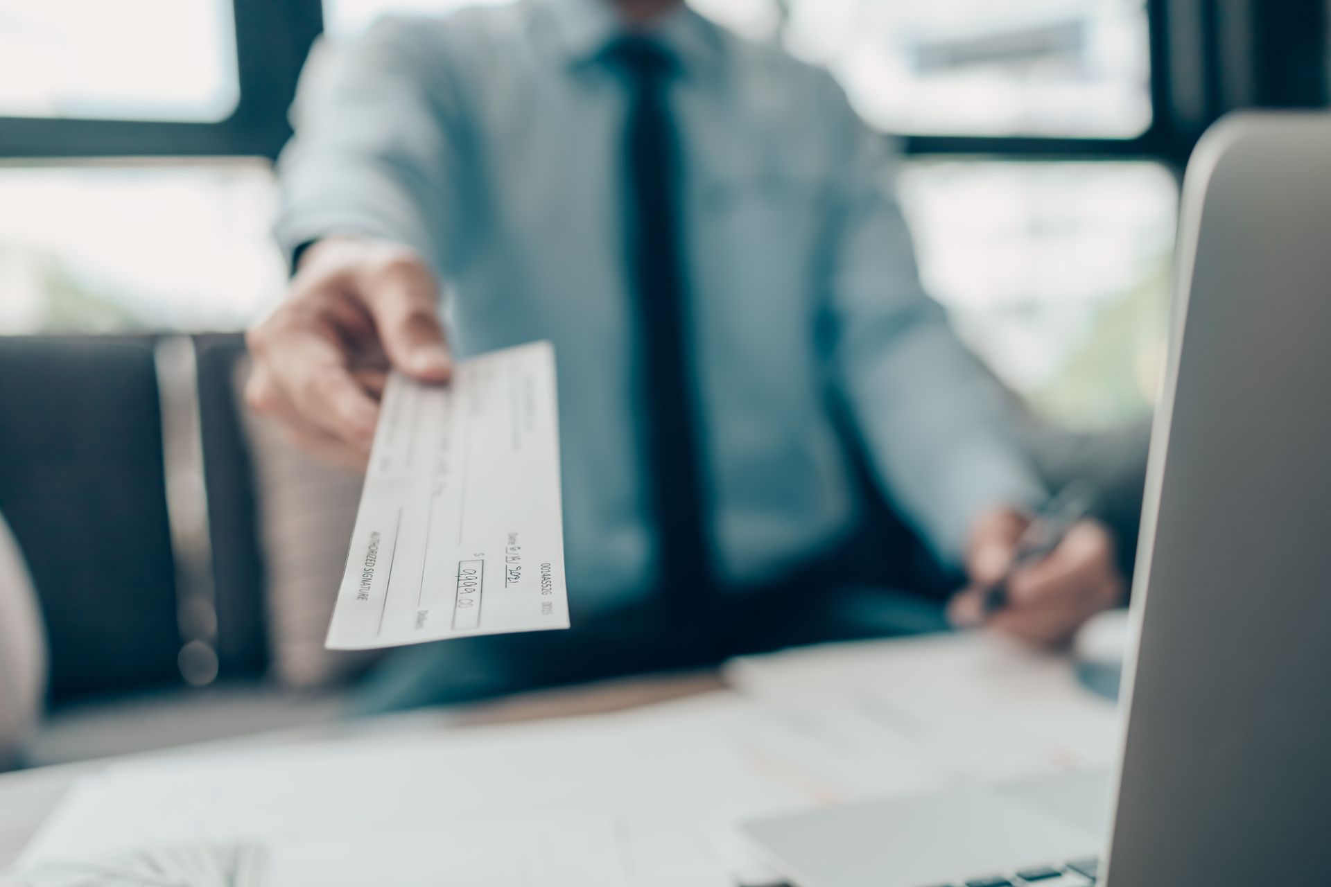 A man handing over a check representing compensation for personal injury