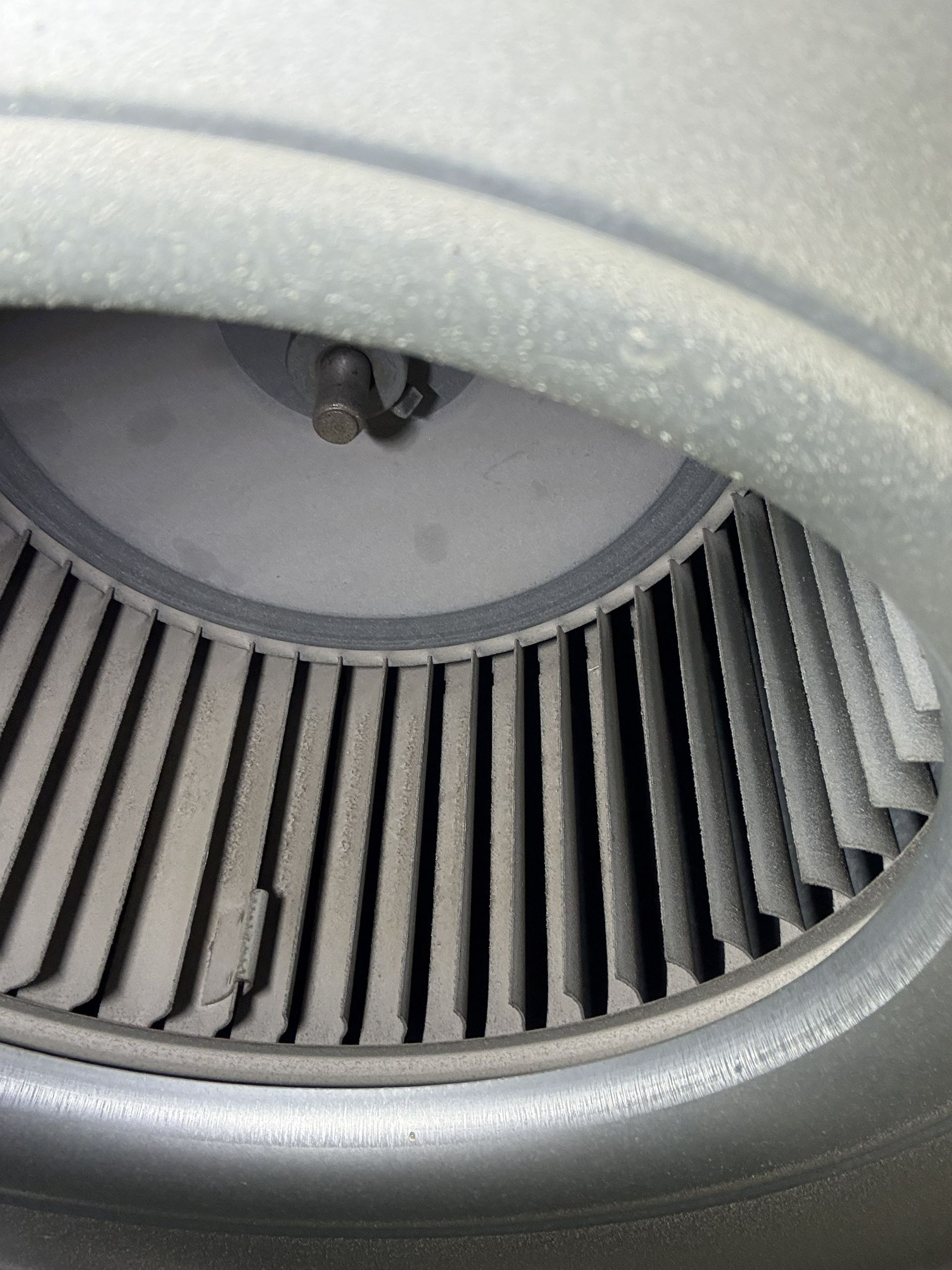Close-up of a silver car air vent with slats and a visible adjustment knob