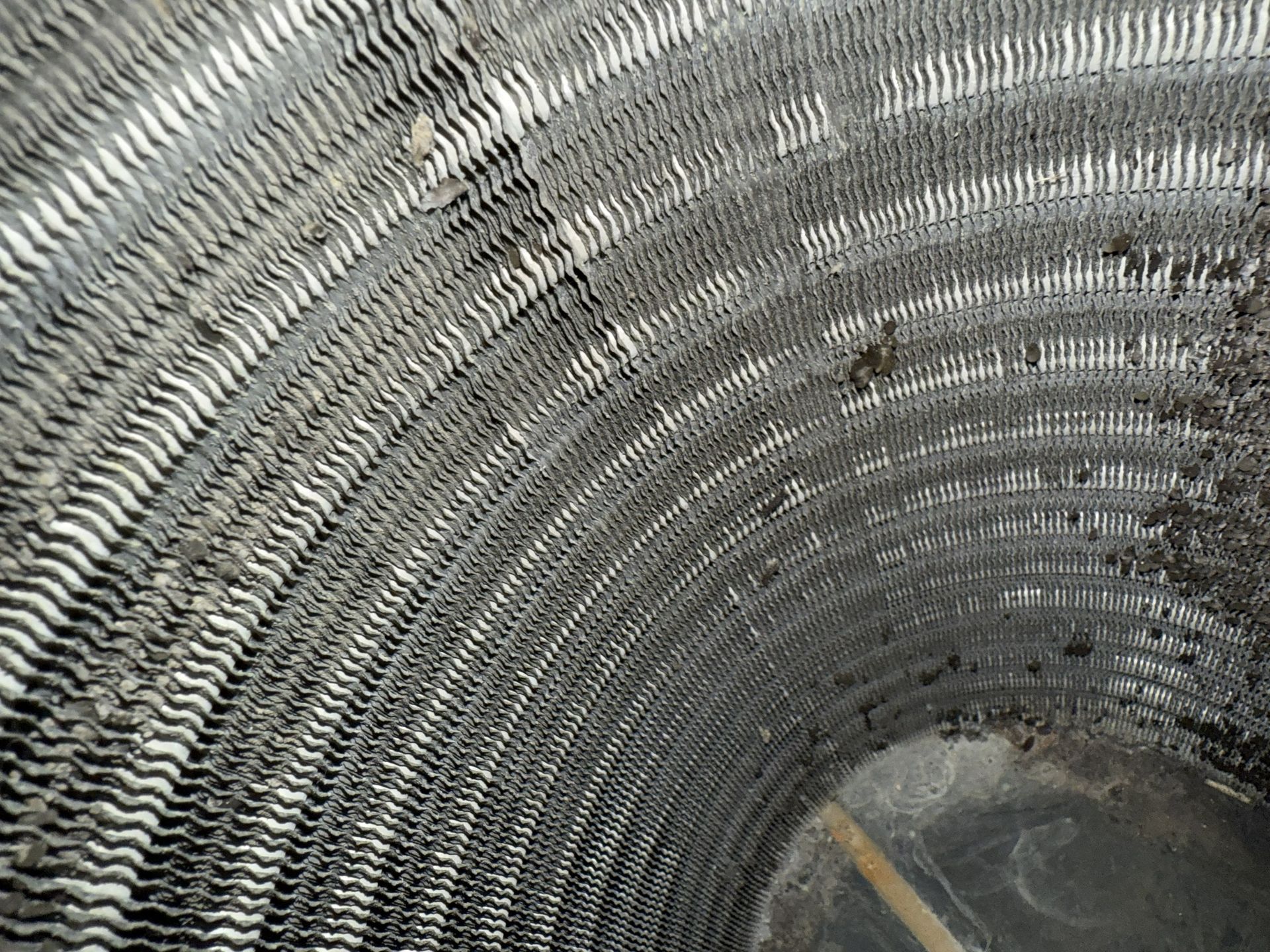 Close-up of a corrugated metal pipe interior with a small insect near the top.