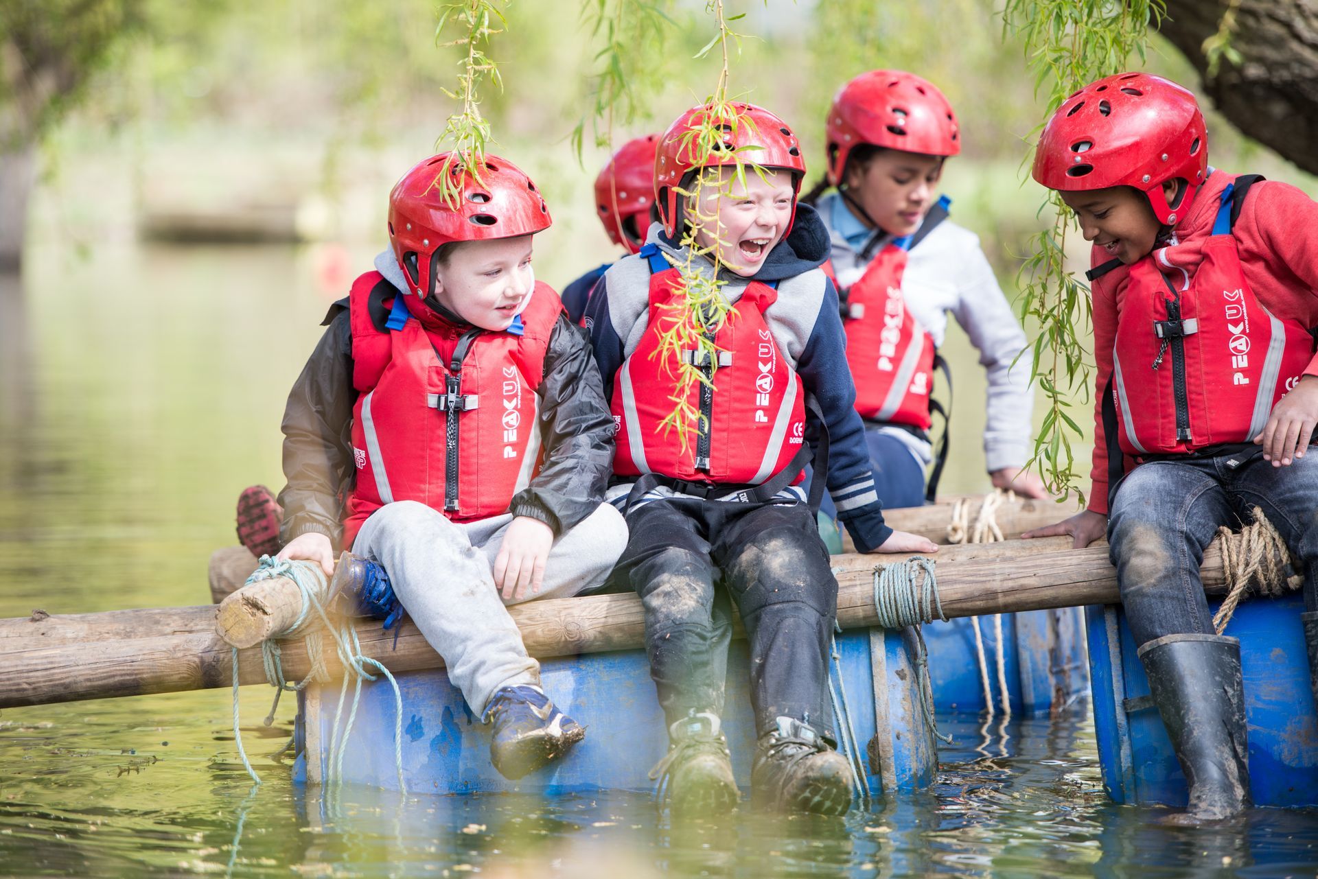 A group of children are sitting on a raft in the water.