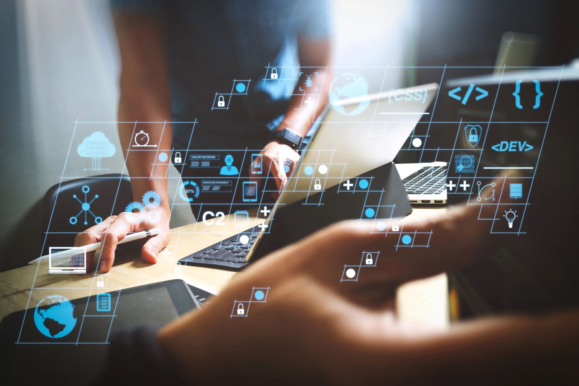 Mani che collaborano attorno a un laptop con icone tecnologiche blu fluttuanti in un moderno ambiente d'ufficio.