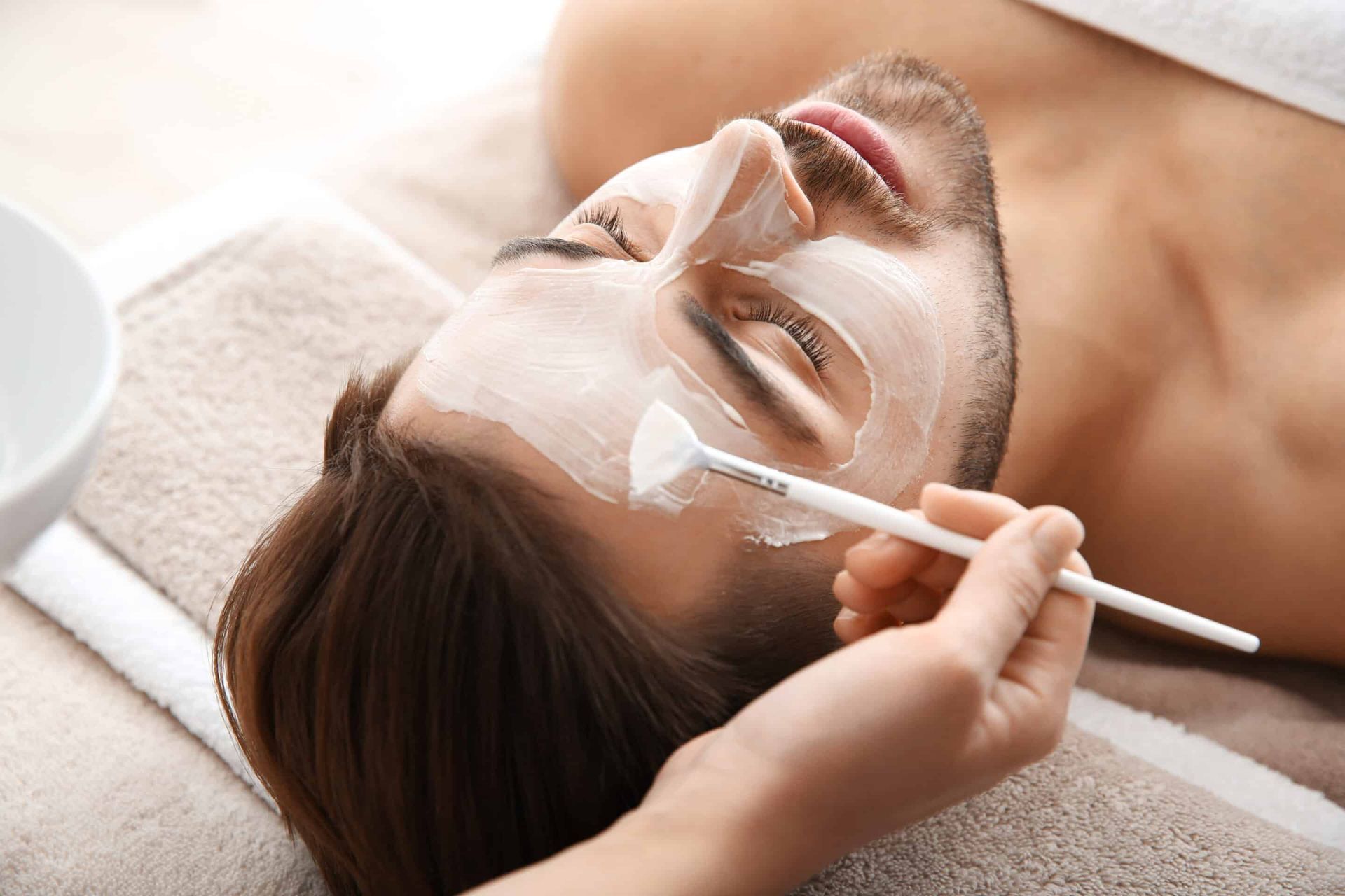 Cosmetologist,Applying,Mask,On,Client's,Face,In,Spa,Salon man getting facial