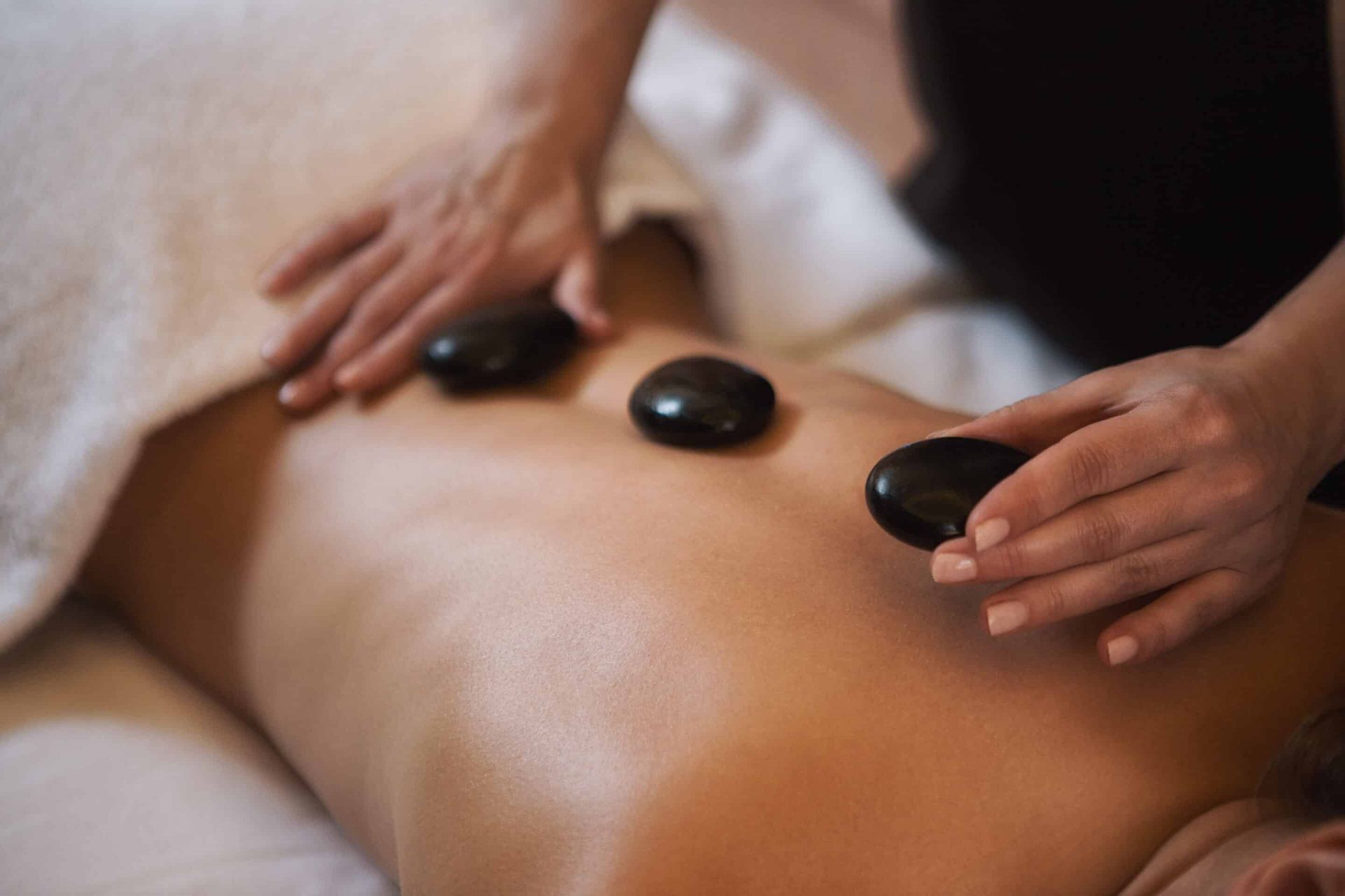 Cropped,Close,Up,Of,A,Professional,Therapist,Masseuse,Doing,Hot hot stone massage