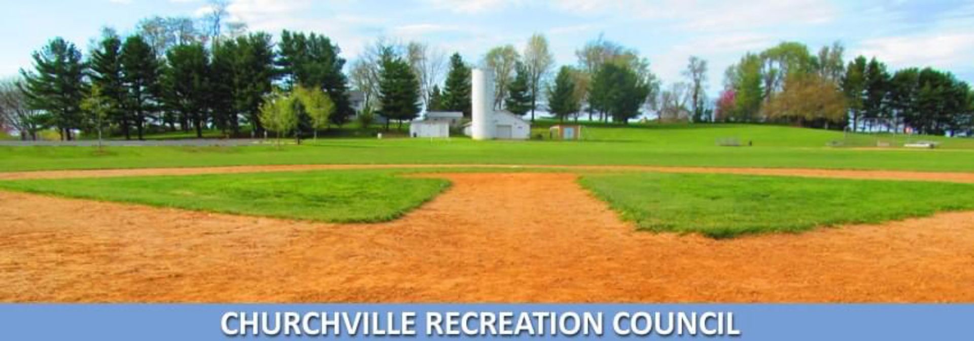 Churchville Recreation Council baseball field with green grass, orange infield, and trees in the background