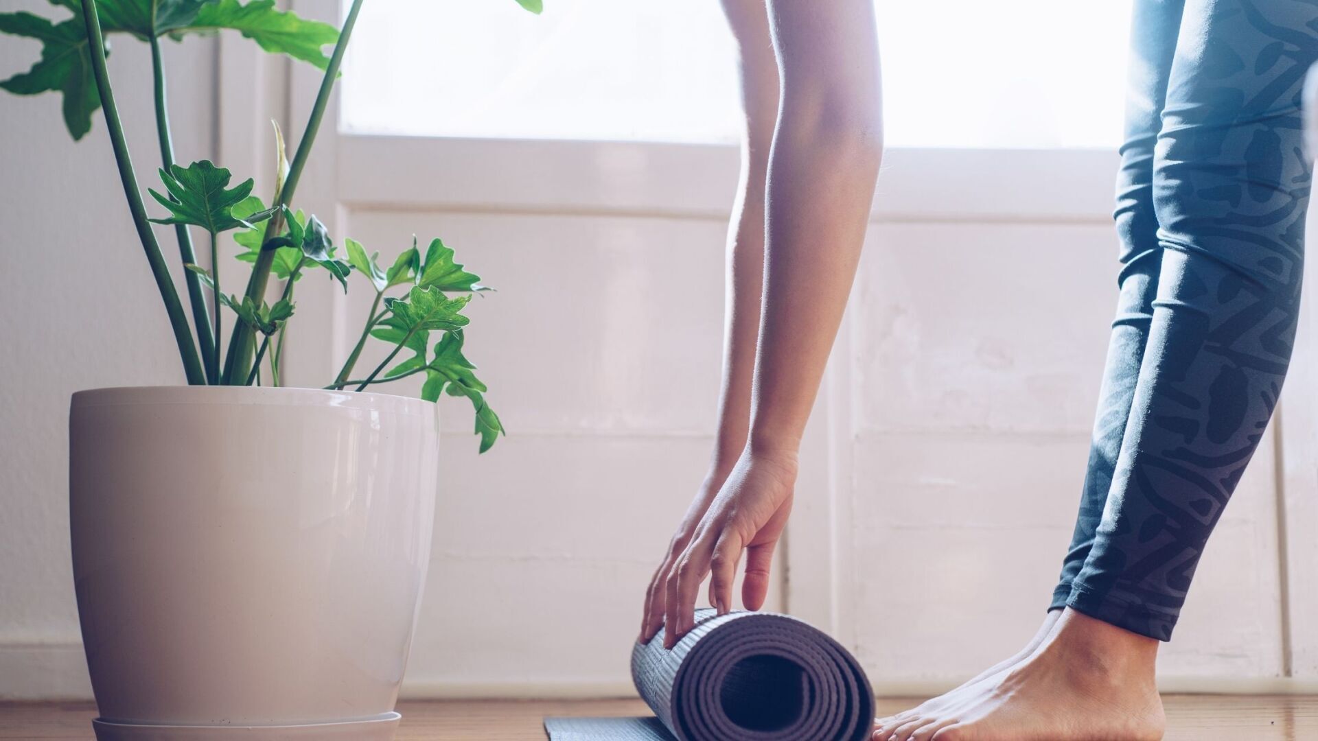 Woman rolling out a yoga mat. Anxiety during recovery
