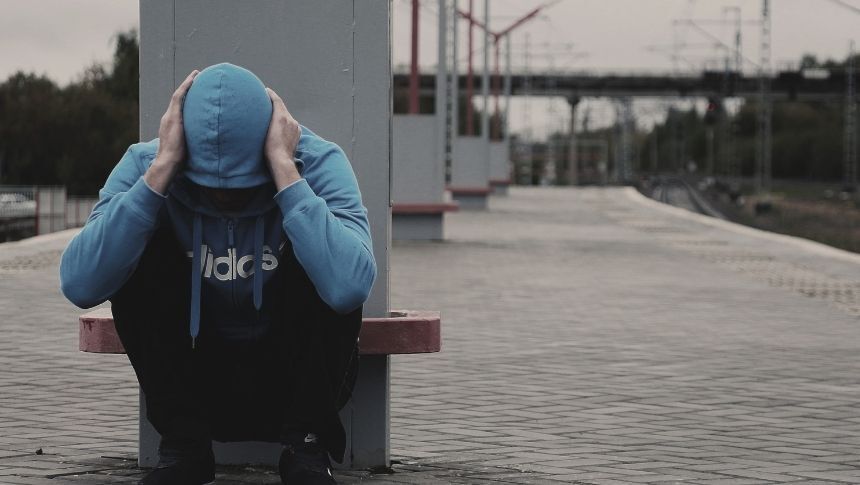 Man feeling hopeless in train station. behavioral-addiction