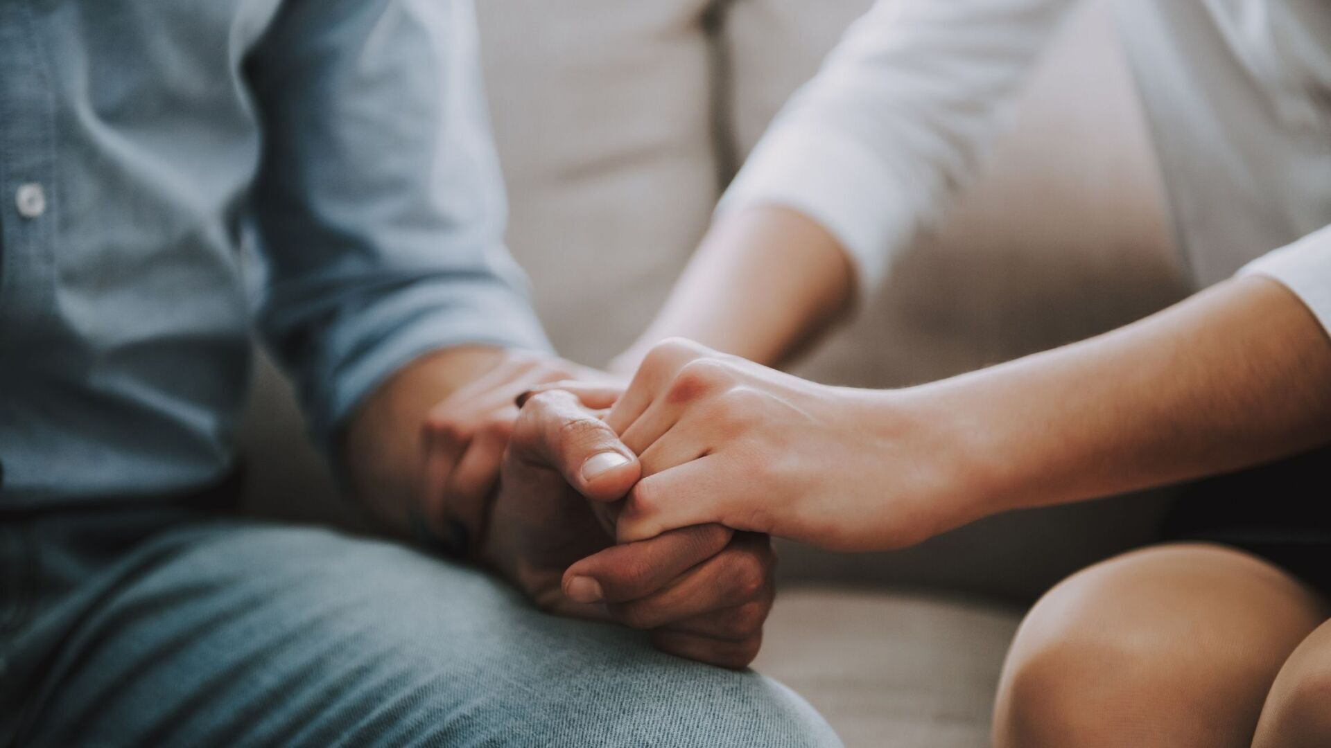 Two individuals clasping each other’s hands. How to Love an Addict Without Enabling