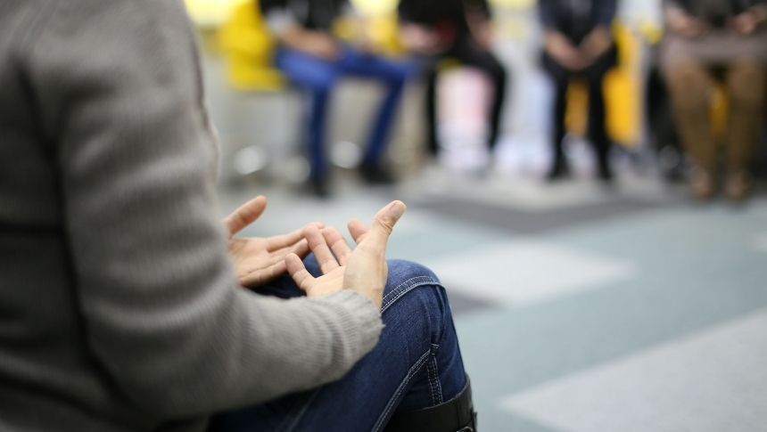 People speaking in a therapy group. Maintaining Sobriety During the Holidays
