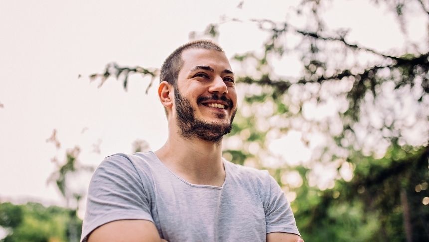 Hopeful man smiling in outside environment. Recover from Addiction - Pathways Recovery Centers