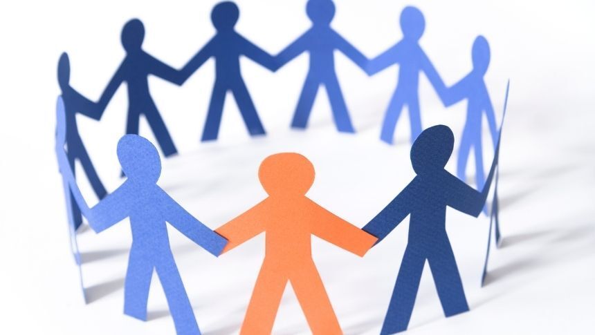 Orange paper person has joined a circle of all-blue paper people. Focus on the orange person. support system for maintaining sobriety