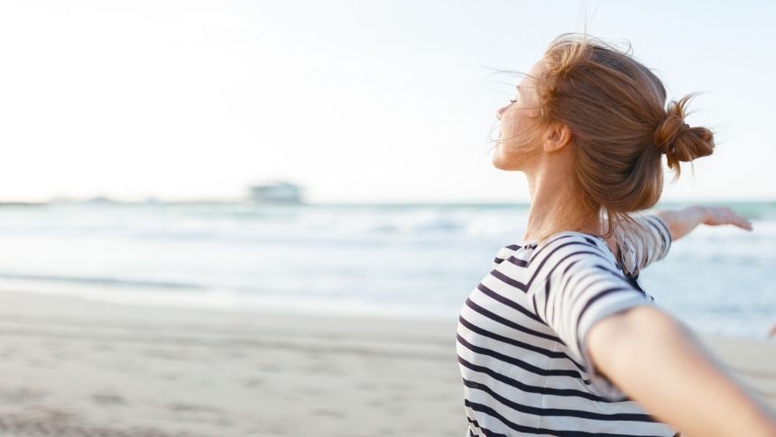Happy woman smiling on the beach. Treating Addiction - Pathways Recovery Centers