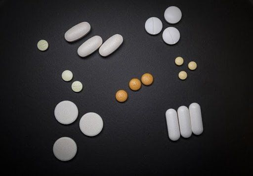A variety of pills lying on a black surface. Addiction Transference