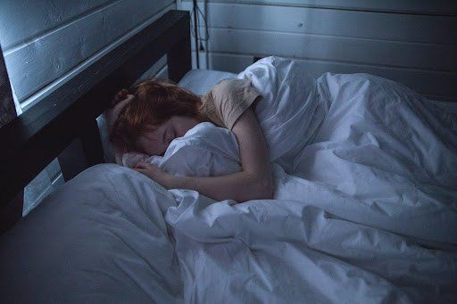 A woman lying in bed, sleeping. How Alcohol Affects Sleep