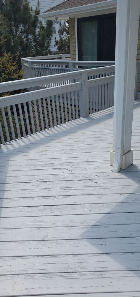 White wooden ramp with railings beside a house on a sunny day