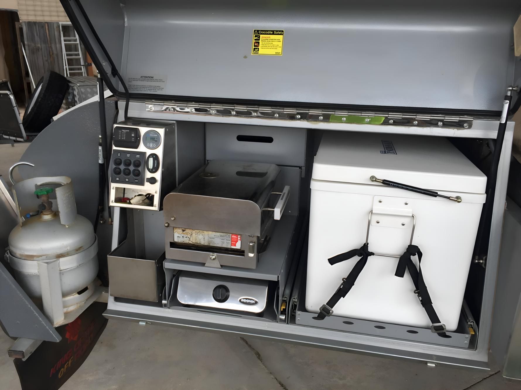 The Inside Of A Trailer With A Propane Tank And A Refrigerator— Coastal Gasfitting & Plumbing In Townsville, QLD