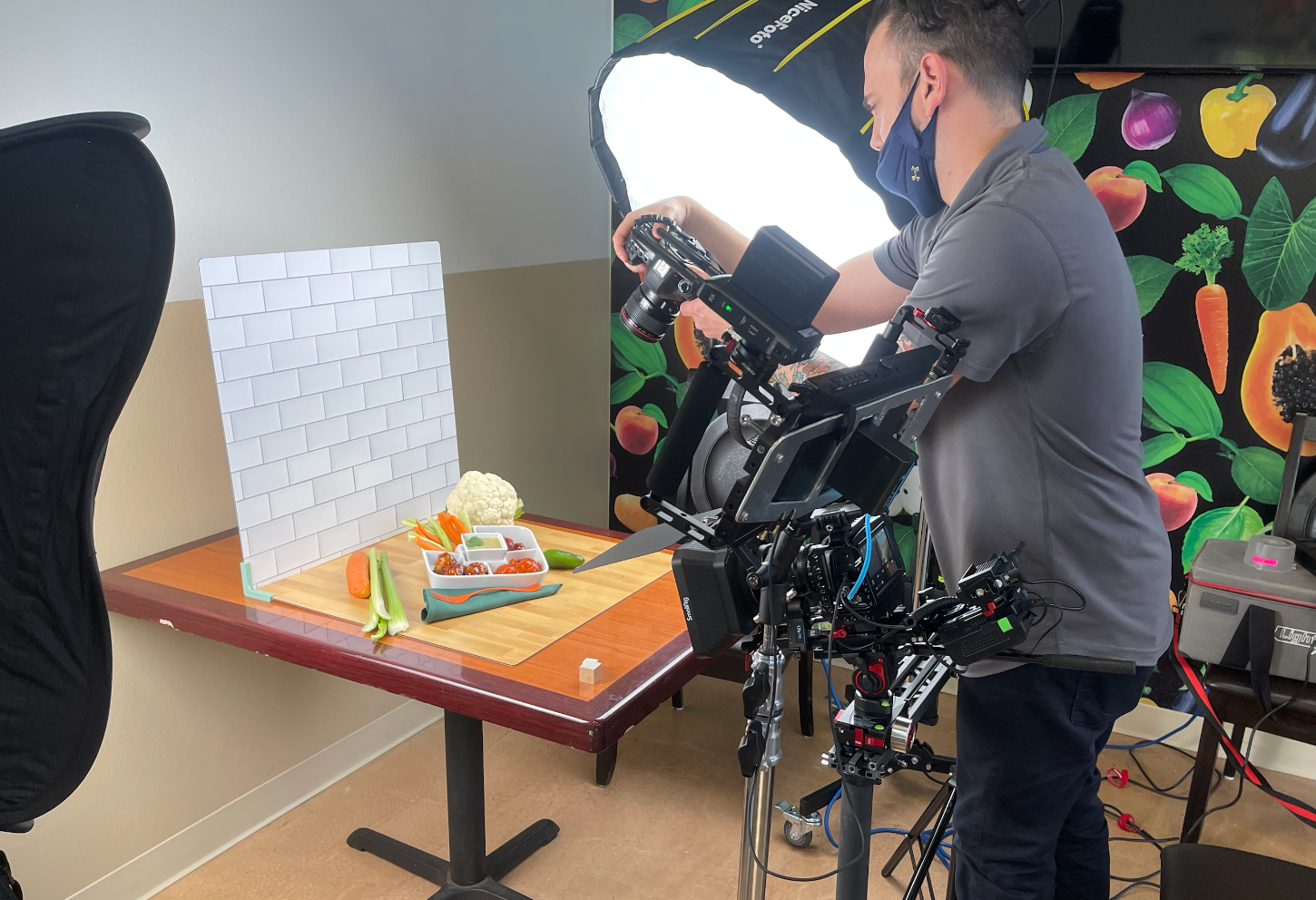 A man is taking a picture of a table with vegetables on it.