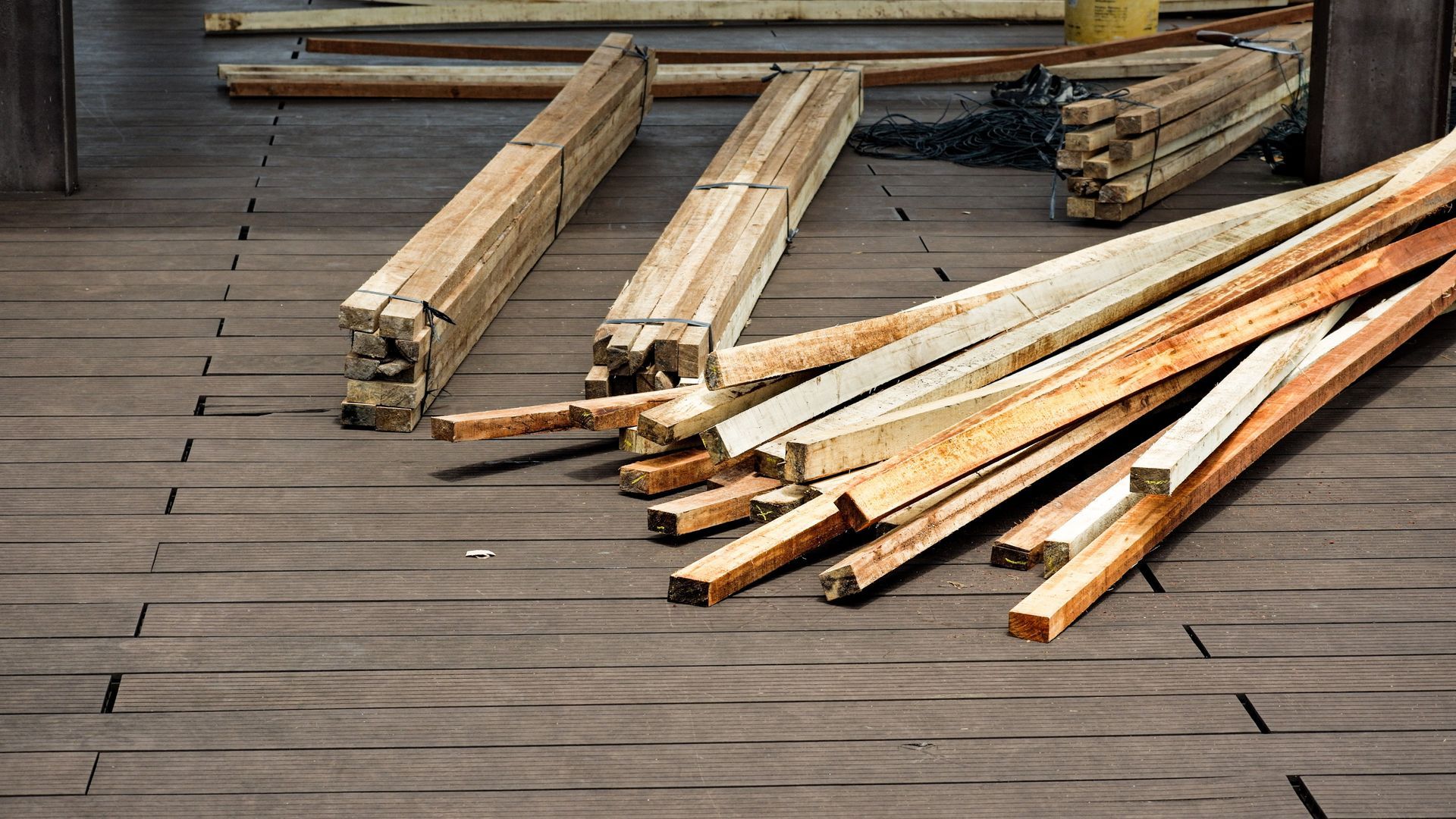 Freshly milled lumber boards stacked on a composite deck, ready to load for a deck supply delivery. Freshly milled lumber boards stacked on a composite deck, ready to load for a deck supply delivery.