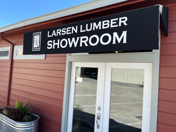 Larsen Lumber Showroom sign above double glass doors, on a red building.