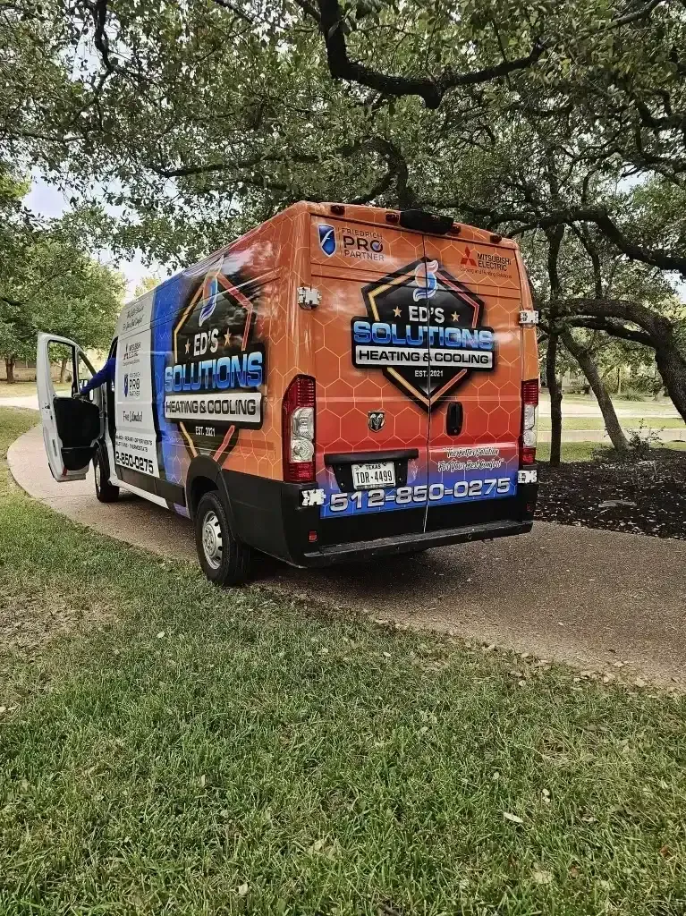 Colorful branded service truck driving on a tree-lined path in a park-like setting