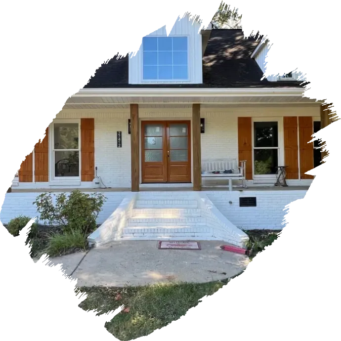 Front view of a white house with a porch, wooden front door, and central walkway.
