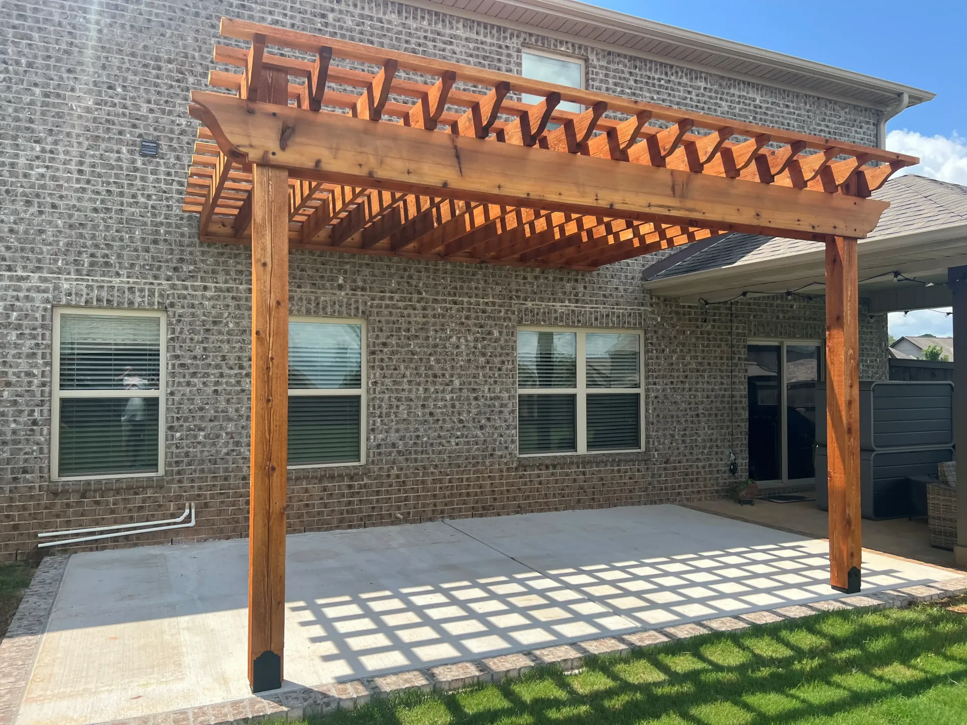 Cedar pergola with fresh stain behind a brick home in Parkside, Meridianville