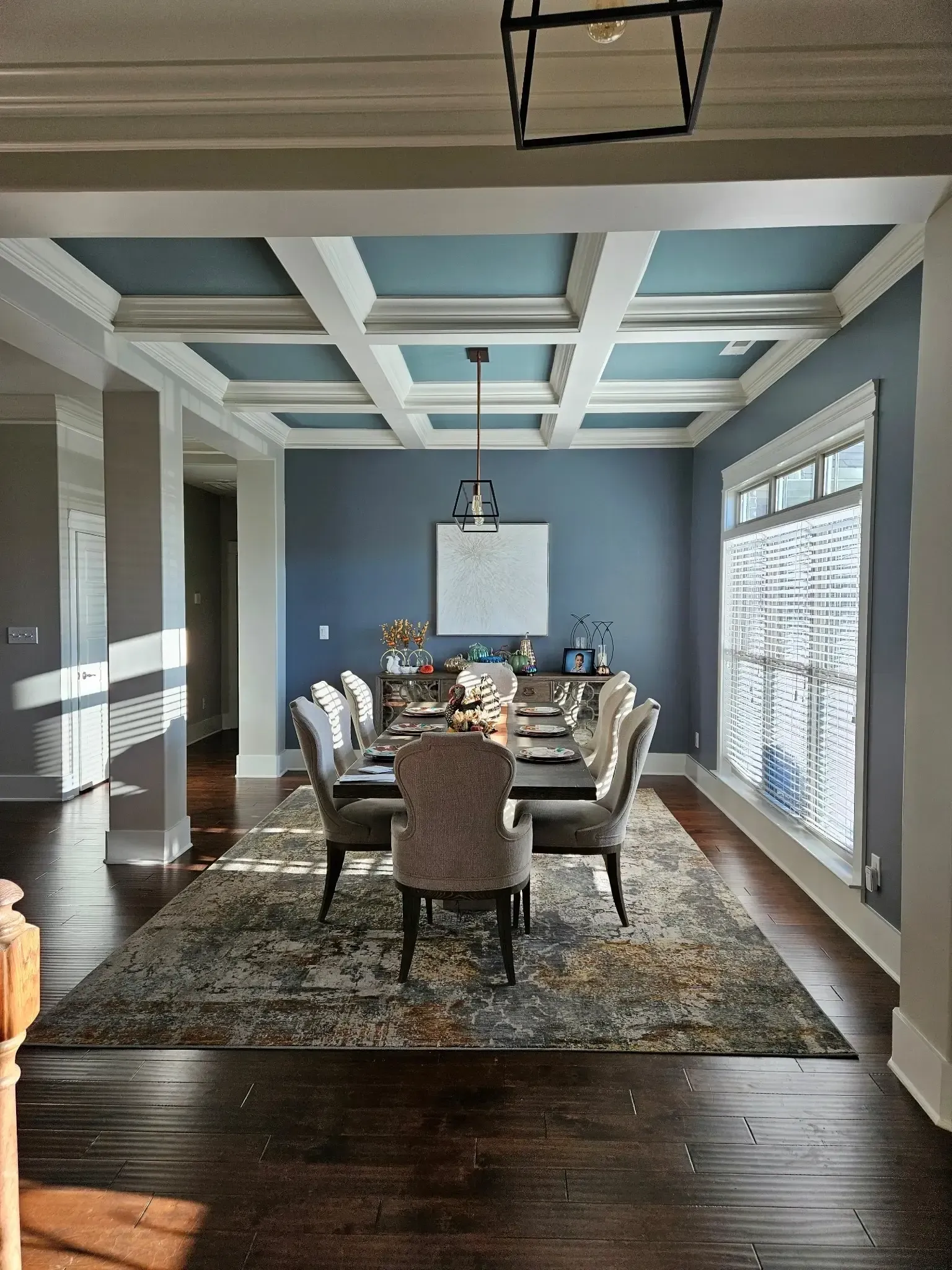 Dining room in Parkside, Meridianville with slate blue walls, a blue coffered ceiling and white trim