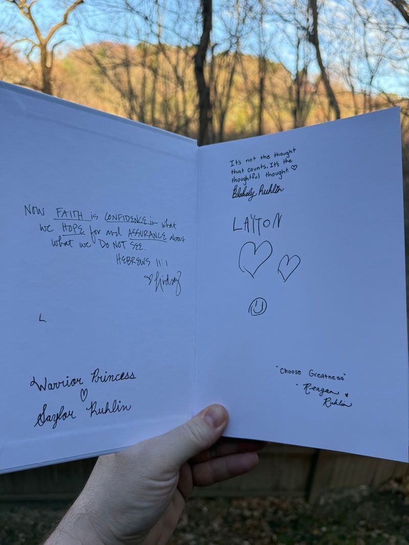A person is holding a card with a mountain in the background.