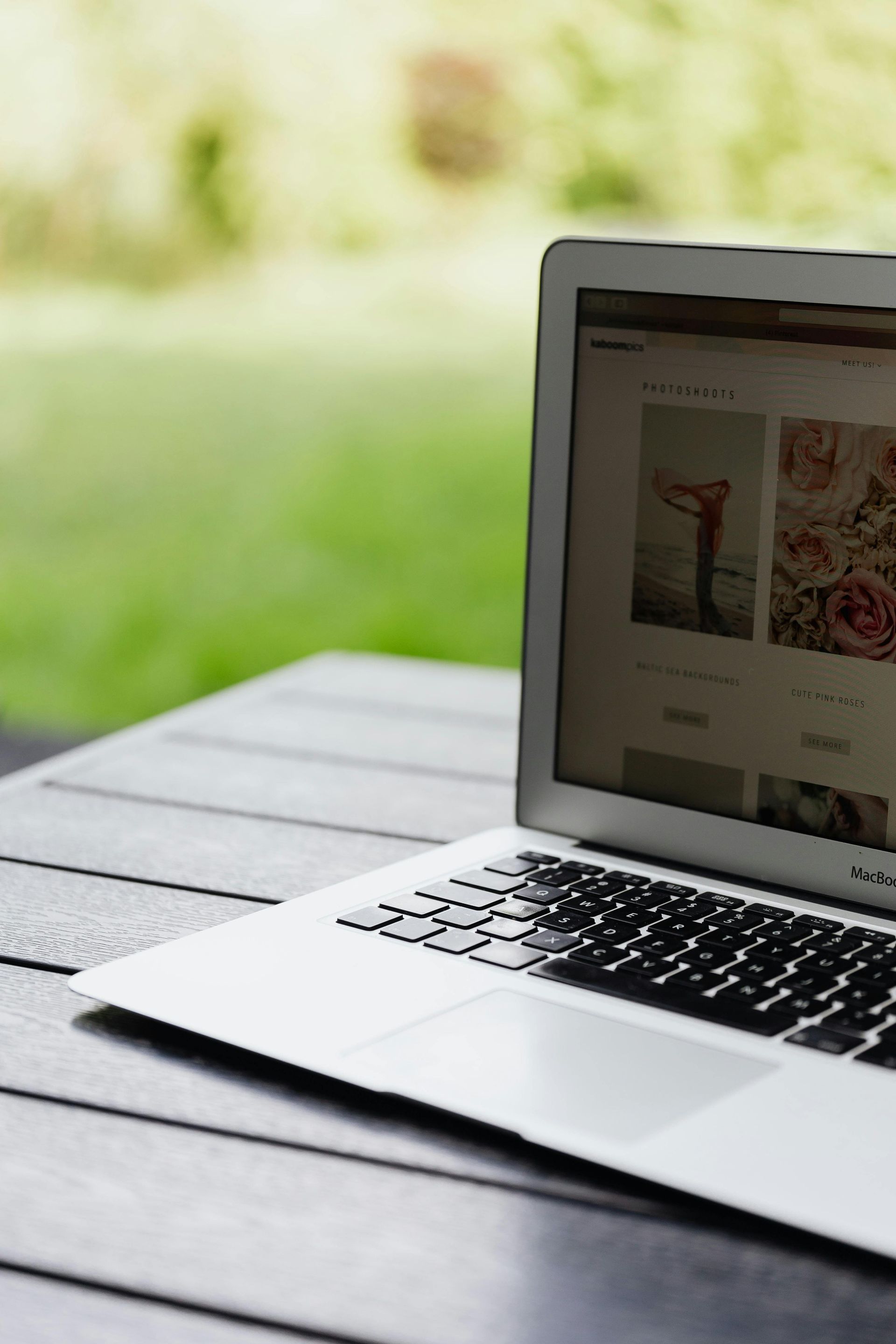 a laptop open with pictures against a backyard backdrop