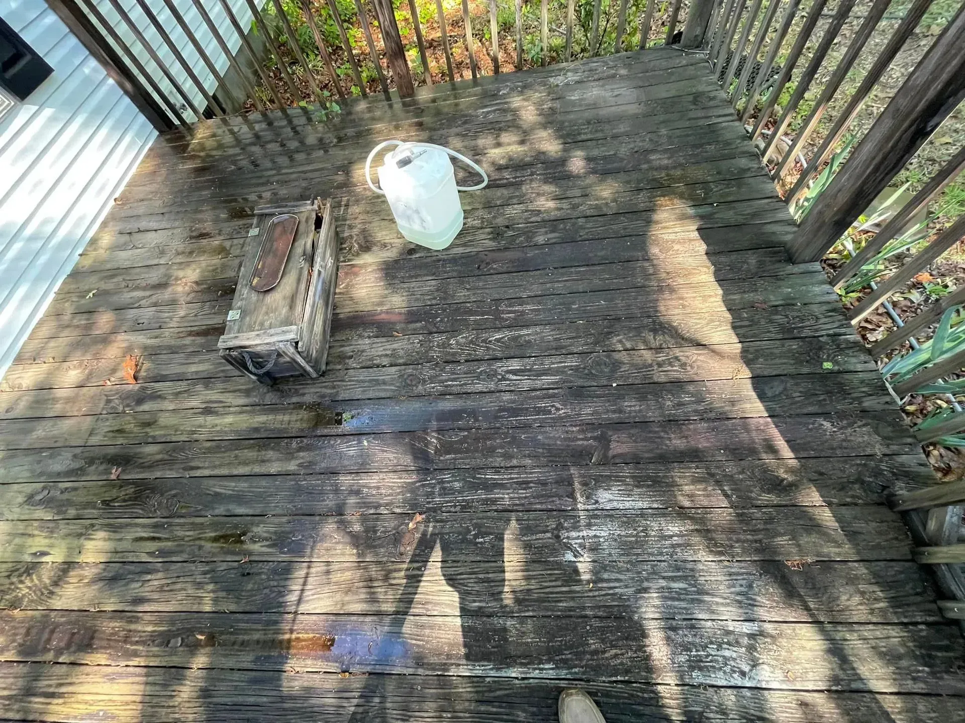 Wooden deck with a metal box and a white pitcher on it.