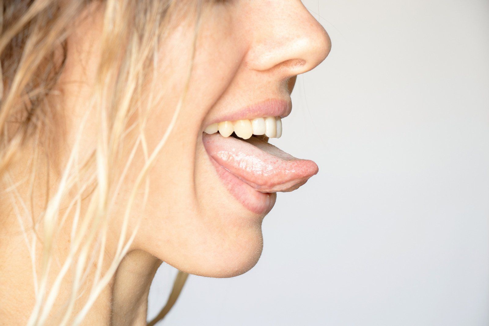 A woman is sticking her tongue out and smiling.