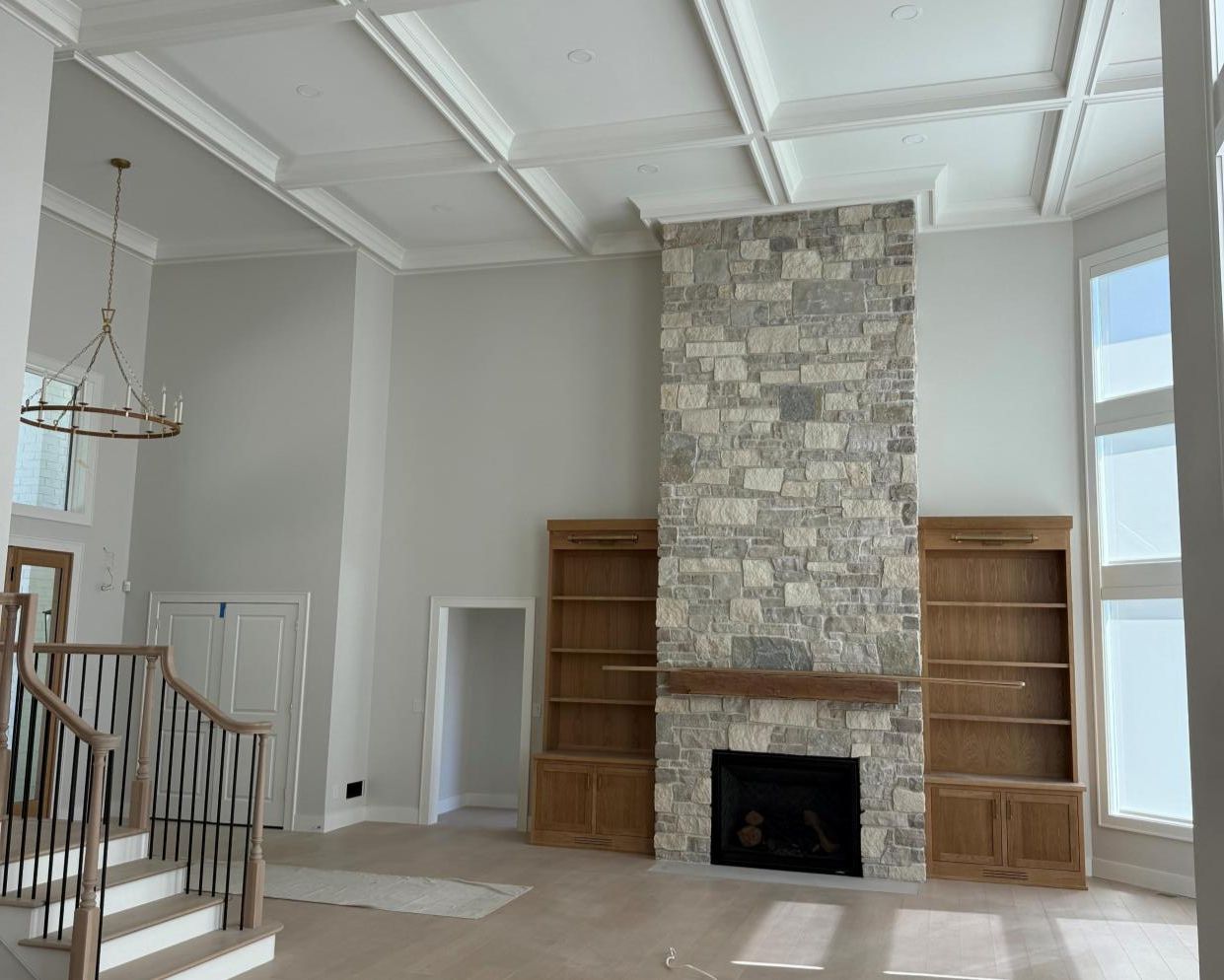 Modern room with dark built-in cabinetry, wood floor, and a light wood sink cabinet under wall sconces