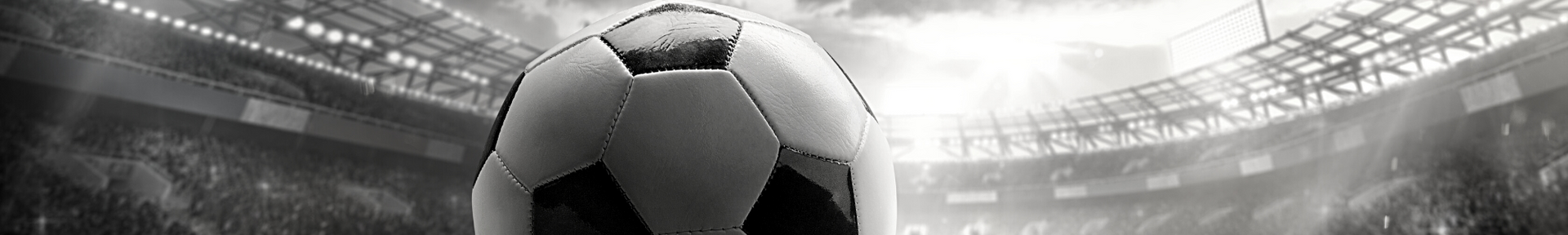 Black-and-white soccer ball centered in a stadium with bright lights and cheering crowd