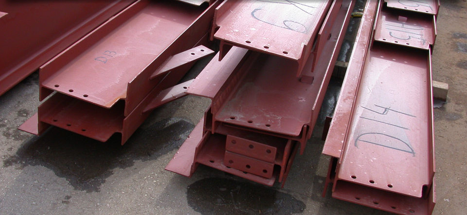 A bunch of red metal beams are stacked on top of each other