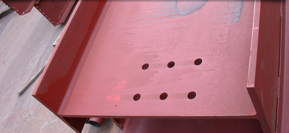 A close up of a red metal item with holes in it.