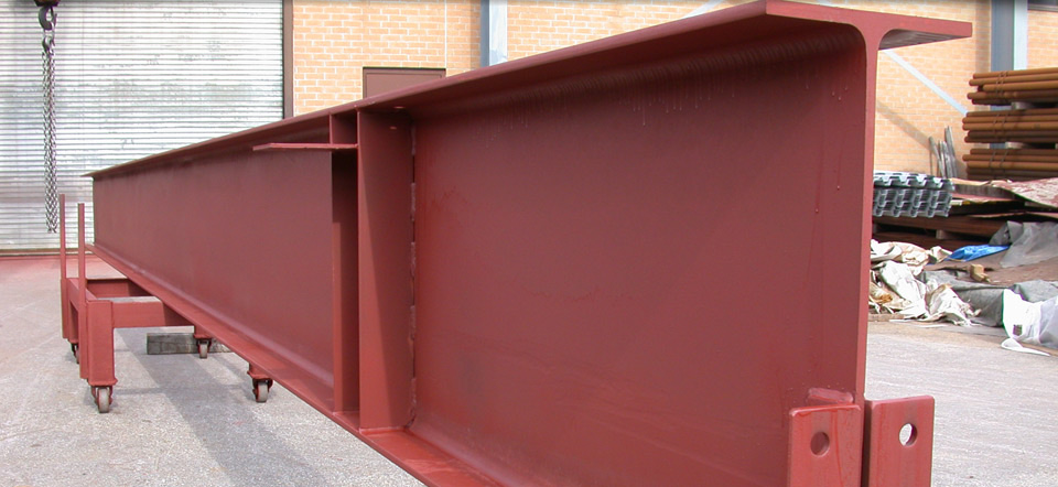 A large red metal beam is sitting on a cart.
