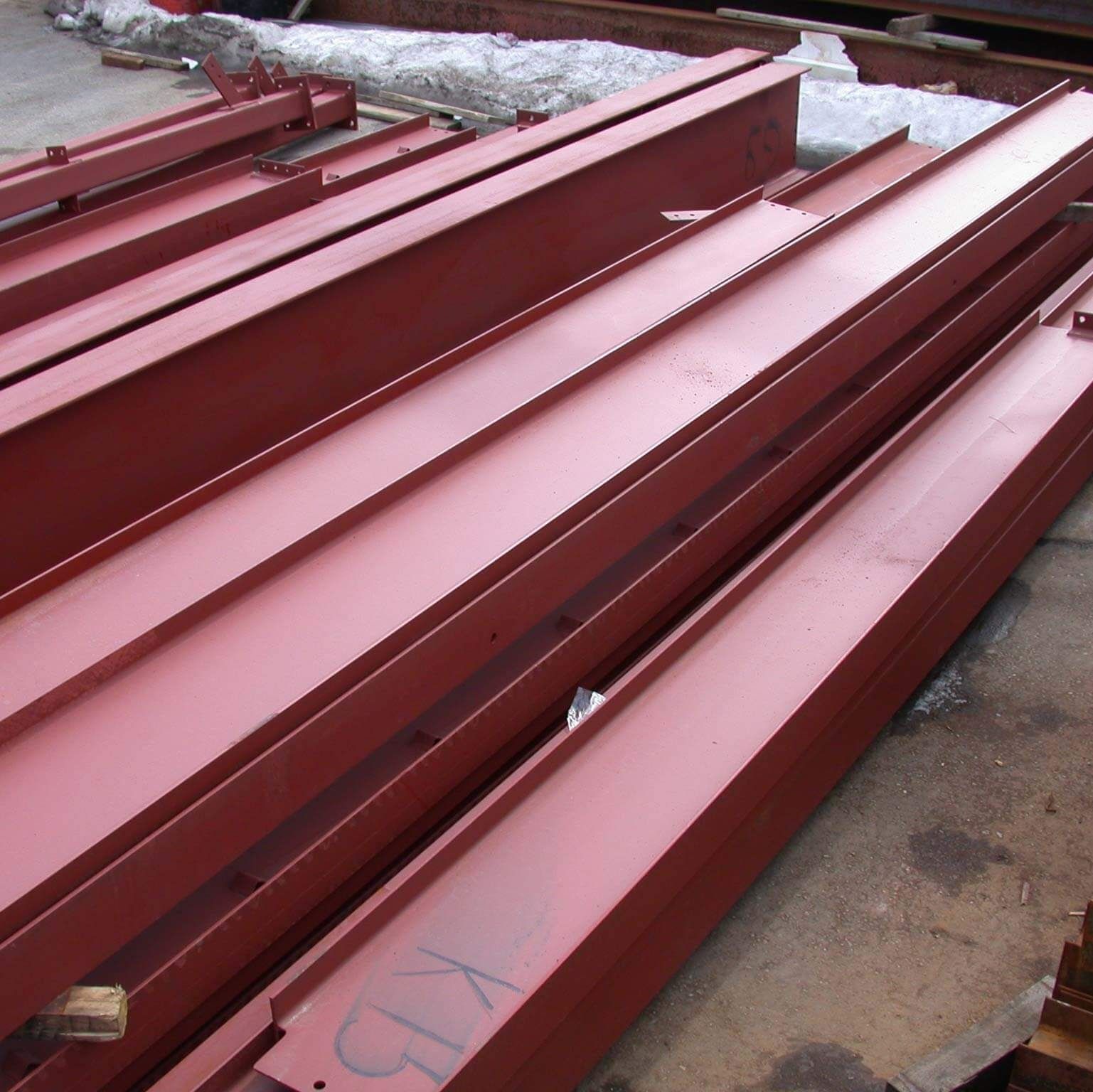 A bunch of red metal beams are stacked on top of each other