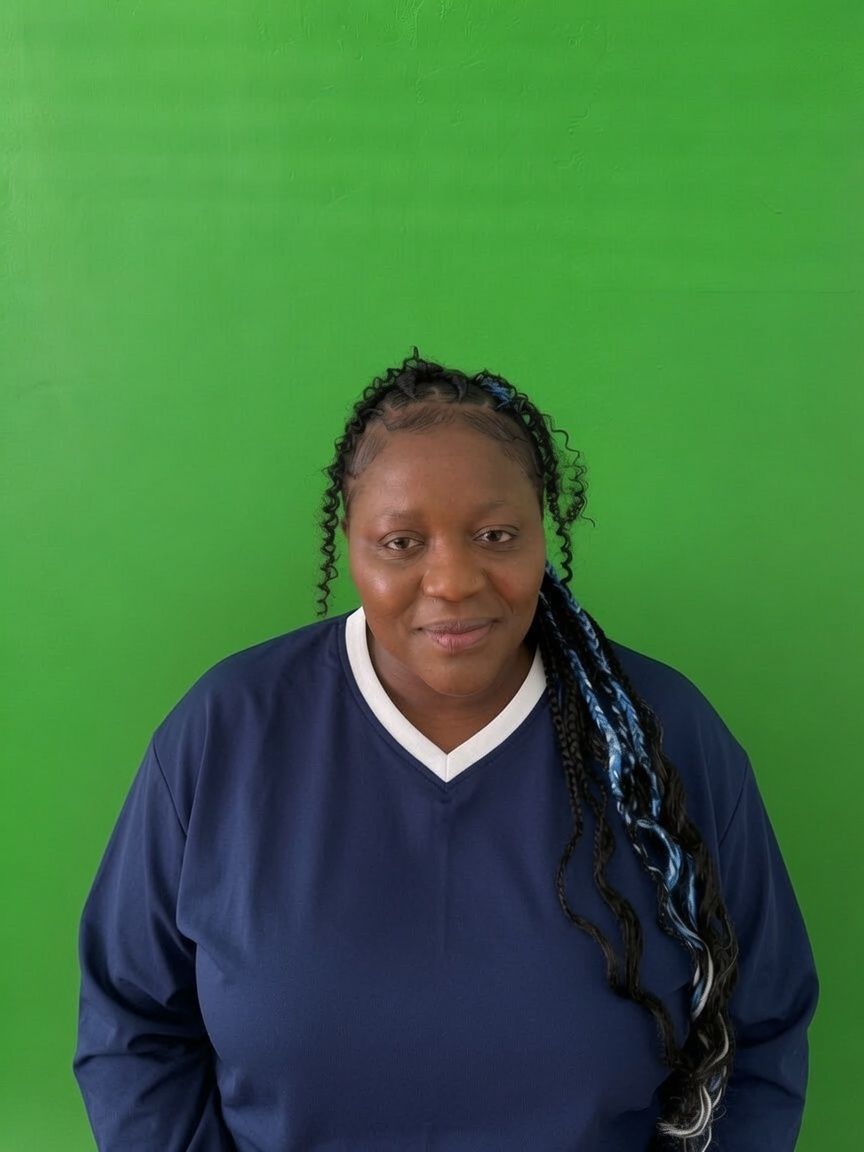 Smiling family assessment centre team member with long dark hair and blue top