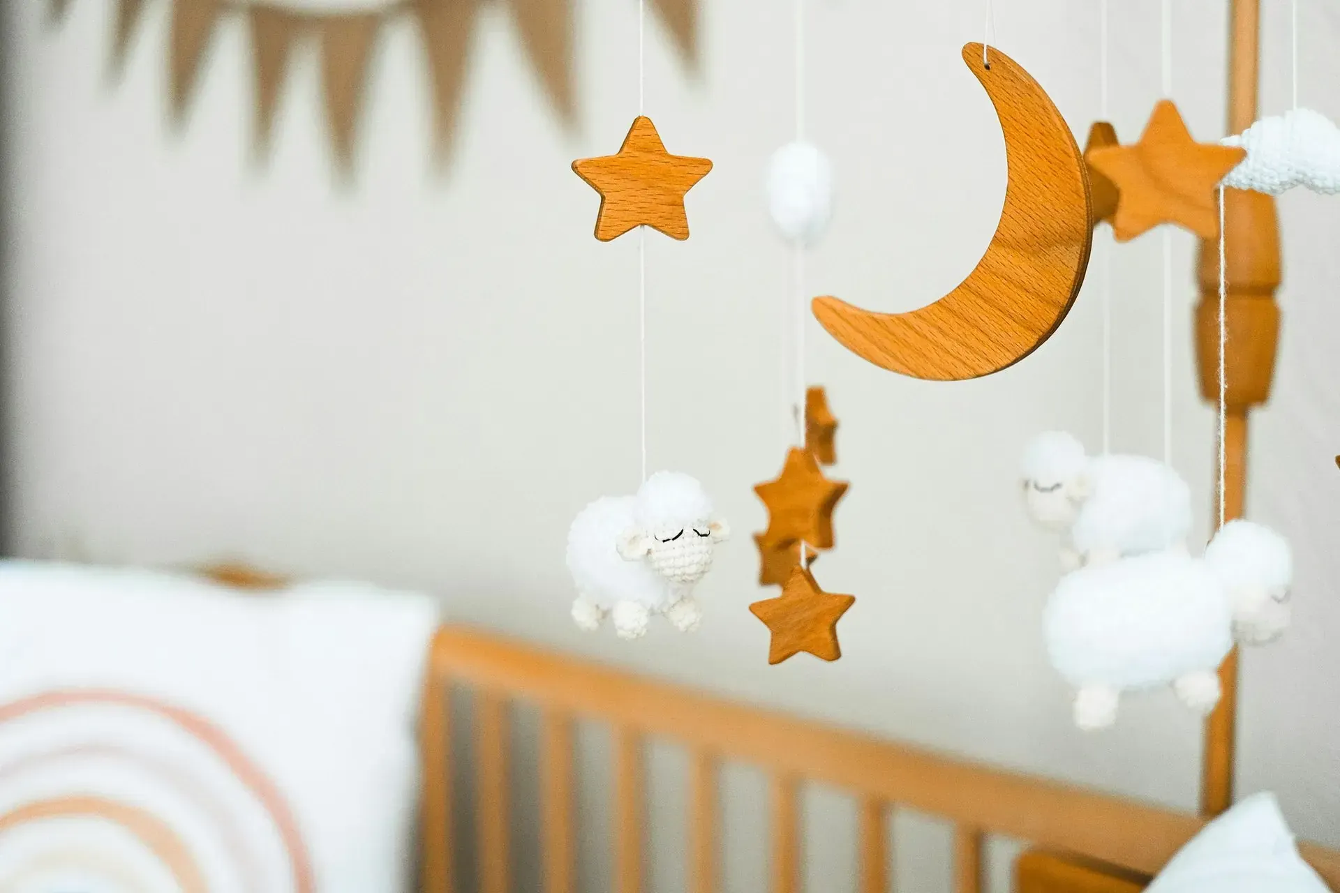 family assessment centre nursery with baby crib and hanging mobile featuring wooden moon, stars, soft sheep toys