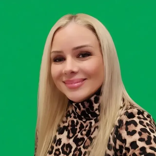 Smiling blonde family assessment centre team member in leopard print top with green background