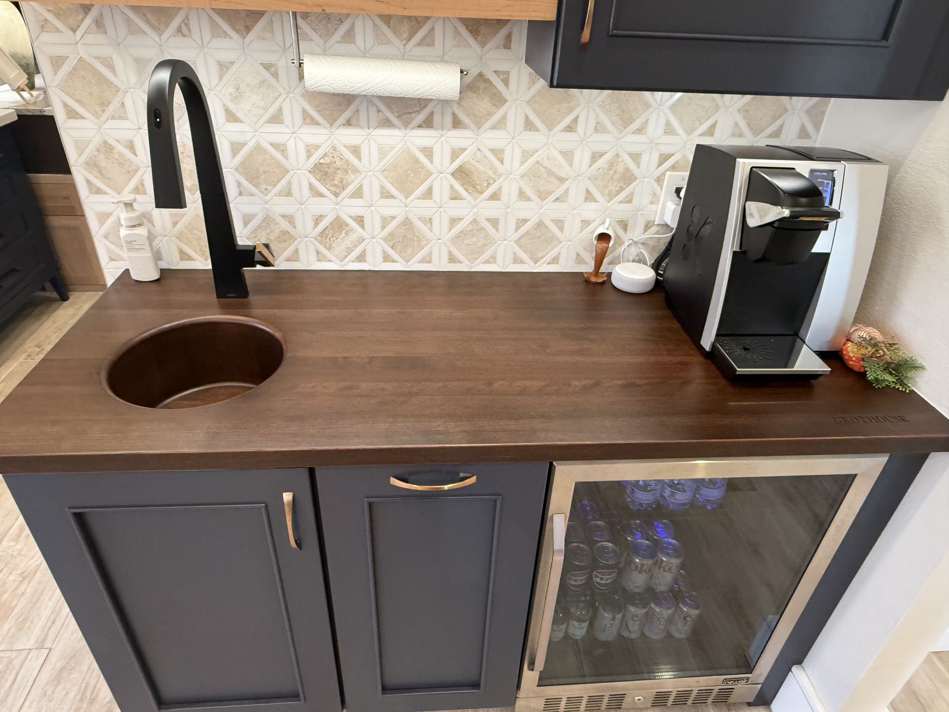 Unique wood sink integrated into Grothouse wood countertop. Navy blue cabinetry.