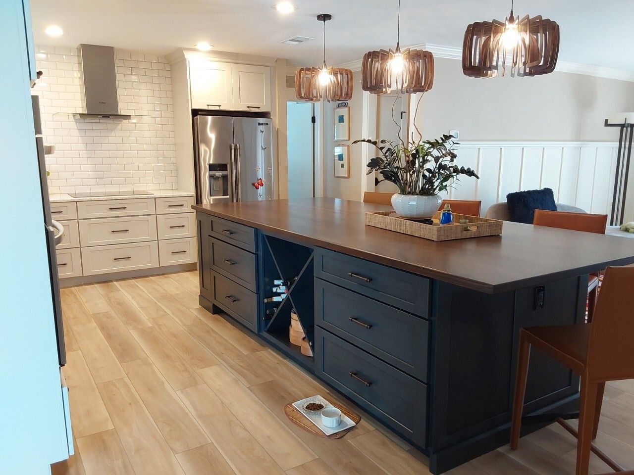 Stunning solid wood top on blue accent island with creative light fixtures. Wine rack base cabinet front and center.