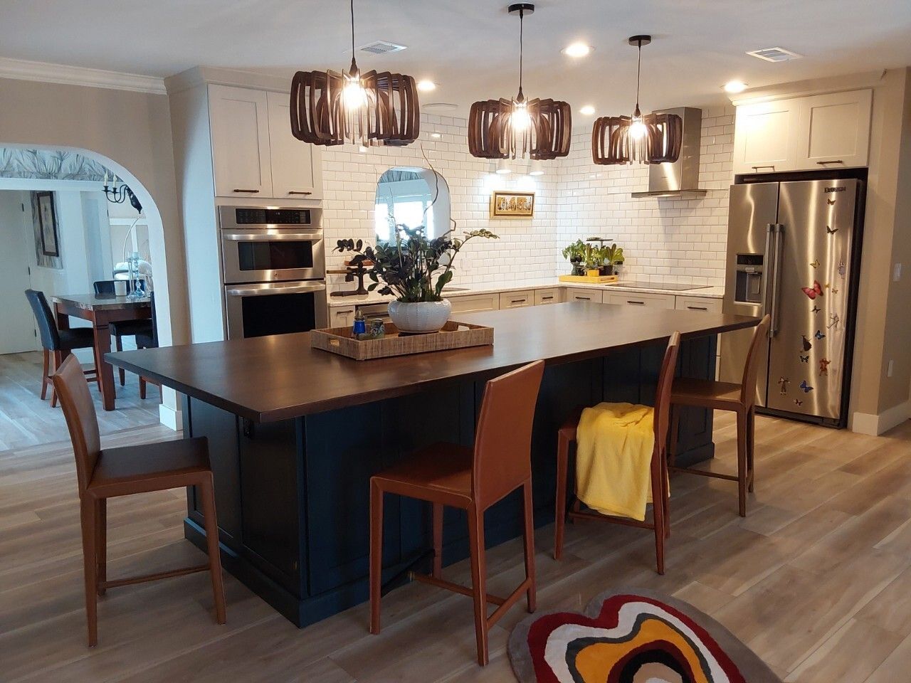 Beautiful navy blue island cabinetry with a dark stained solid wood countertop, a perfect accent to the white perimeter